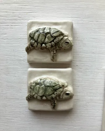 Ceramic tiles featuring textured turtle designs. The turtles are crafted in a realistic style, showcasing details like shells and facial features.