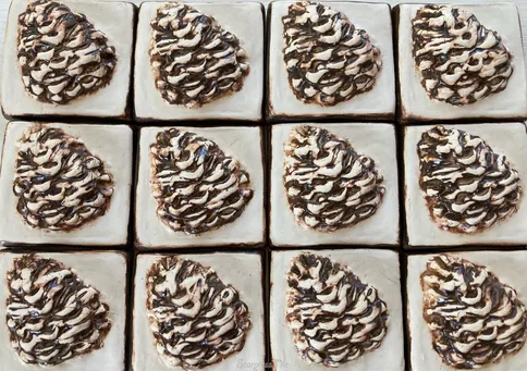 Decorative pastries arranged in a grid, featuring swirls of chocolate and cream toppings. Ideal for a bakery display or dessert menu.